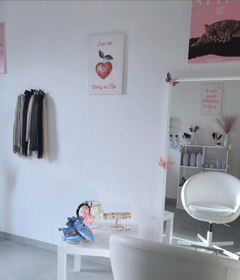 Interieur van Luxani Studio met witte salonstoelen, haarextensions en decoratieve details